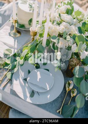 Cadre de table élégant avec une carte vierge décorée de branches d'eucalyptus. Maquette de mariage. Table romantique avec carte d'invitation en papier. Banque D'Images