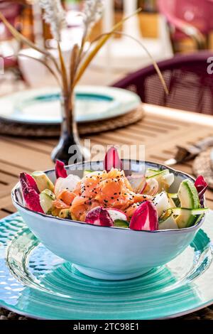 portrait d'un bol de salade de saumon fraîchement préparé et d'avocat dans un restaurant méditerranéen. Banque D'Images