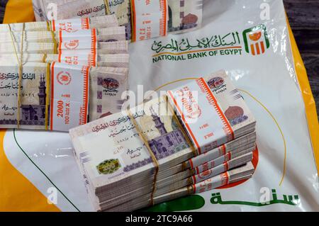 Le Caire, Egypte, novembre 26 2023 : piles et piles d'argent de l'Egypte des milliers de livres billets de banque billets de 200 EGP LE, avec un sac d'argent de Natio Banque D'Images