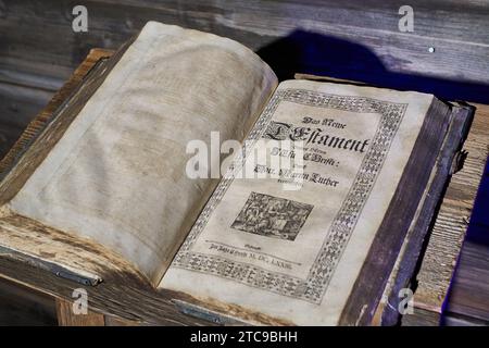 Une très vieille bible ouverte assise sur une vieille table en bois Banque D'Images