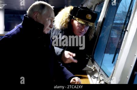 Severodvinsk, Russie. 11 décembre 2023. Le président russe Vladimir Poutine, accompagné du commandant en chef de la marine russe, l'amiral Nikolaï Yevmenov, à droite, visite le pont à bord de la frégate de classe amiral Gorshkov de la marine russe, l'amiral Kasatonov, au chantier naval de Sevmash, le 12 décembre 2023 à Severodvinsk, région d'Arkhangelsk, Russie. Crédit : Mikhael Klimentyev/Kremlin Pool/Alamy Live News Banque D'Images