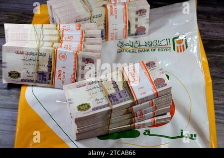 Le Caire, Egypte, novembre 26 2023 : piles et piles d'argent de l'Egypte des milliers de livres billets de banque billets de 200 EGP LE, avec un sac d'argent de Natio Banque D'Images