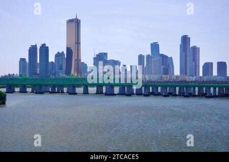 Les ponts ferroviaires de Hangang enjambent le fleuve Han, magnifiquement encadrés par l'horizon saisissant de Yeouido en toile de fond, mettant en valeur la ville dynamique de Séoul Banque D'Images