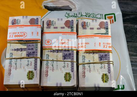 Le Caire, Egypte, novembre 26 2023 : piles et piles d'argent de l'Egypte des milliers de livres billets de banque billets de 200 EGP LE, avec un sac d'argent de Natio Banque D'Images