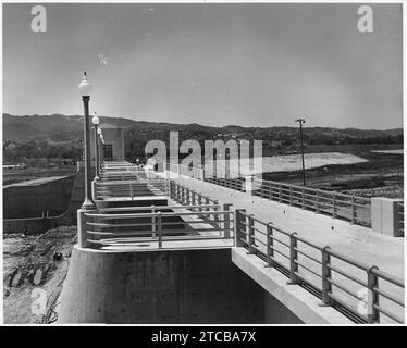 Vue vers l'ouest, le long du dessus du déversoir, montrant la passerelle de service et les mains courantes terminées. Le contrôle de sortie... Banque D'Images