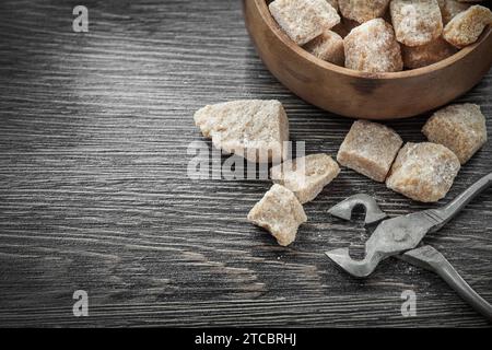 Bol de pinces à sucre brun sur planche en bois vintage Banque D'Images