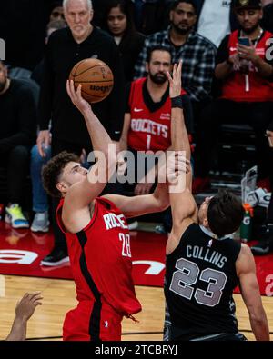 Houston, États-Unis. 11 décembre 2023. Alperen Sengun (L) des Rockets de Houston se présente pour une mise en échec lors du match de saison régulière de la NBA 2023-2024 entre les Rockets de Houston et les Spurs de San Antonio à Houston, aux États-Unis, le 11 décembre 2023. Crédit : Chen Chen/Xinhua/Alamy Live News Banque D'Images