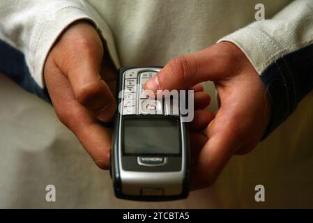 Image posée par un modèle. Photo de dossier datée du 29/04/2017 d'un enfant tenant un téléphone portable. Des monuments à travers l'Écosse brilleront de vert la semaine prochaine pour rappeler aux jeunes que Childline est prêt à les soutenir pendant les fêtes de fin d'année. Date d'émission : mardi 12 décembre 2023. Banque D'Images