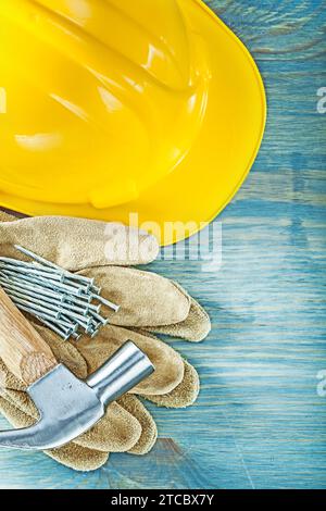 Casque de sécurité gants de sécurité en cuir clous de marteau de griffe sur le concept de construction de planche de bois Banque D'Images