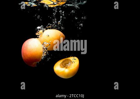 Nectarine fraîche avec de l'eau splash sur fond noir isolé. Concept de santé Banque D'Images