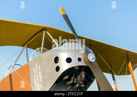 Cockpit avec un moteur avec une hélice et des ailes d'un avion vintage jaune contre un ciel bleu en gros plan dans l'isolement Banque D'Images