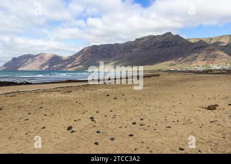 Côte et plage de sable Playa de Famara avec chaîne de montagnes et vagues sur l'île des canaries Lanzarote, Espagne Banque D'Images
