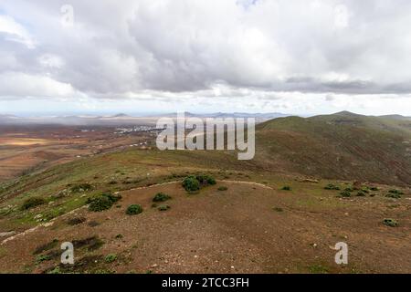 Vue panoramique au paysage depuis le point de vue Mirador Morro Velosa sur Fuerteventura, Espagne avec une végétation verte et des collines volcaniques multicolores Banque D'Images