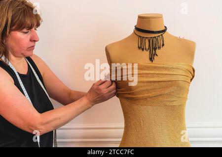 Créateur de mode mettant des épingles dans le tissu sur le mannequin Banque D'Images