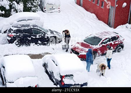 Femmes pelletant la neige sur le parking, voiture, voiture, neige fraîche, fortes chutes de neige, masses de neige, chaos de neige, pelle à neige, début de l'hiver, Marzling Banque D'Images
