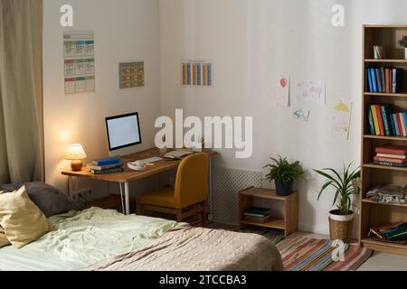 Chambre moderne d'adolescent avec lieu de travail et moniteur d'ordinateur sur elle Banque D'Images