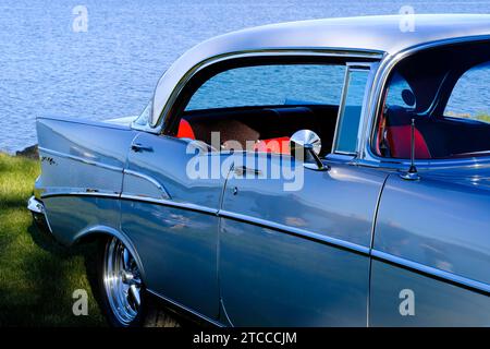 Voiture vintage américaine, Chevrolet Bel Air de 1957, vue partielle, bleu avec sièges rouges, lac Vaenern à l'arrière, Amal, Vaestra Goetaland, Suède Banque D'Images
