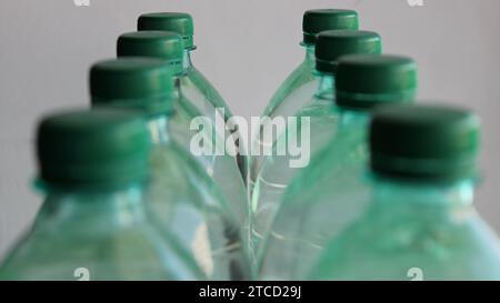 Deux rangées de bouteilles d'eau en plastique avec accent sur les dernières bouteilles isolées sur blanc Banque D'Images