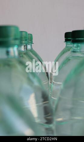 Bouteilles en plastique réutilisables avec bouchons verts remplis d'eau purifiée photo de stock Banque D'Images