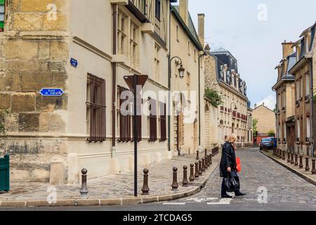 C'est une femme inconnue traversant la route dans le centre historique le 15 mai 2015 à Reims, France. Banque D'Images