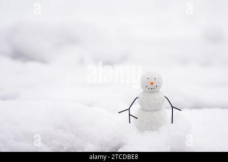 Un bonhomme de neige heureux dans la rue restant dans la neige, fond blanc avec espace de copie Banque D'Images