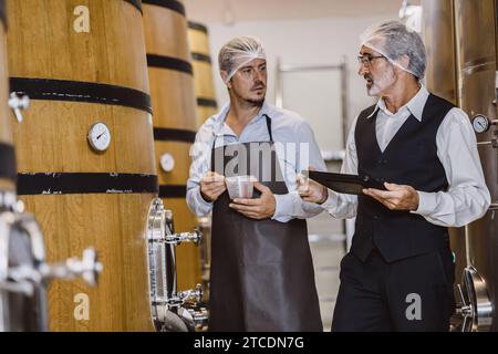 Viticulteur professionnel travaillant dans une grande usine de vinification moderne alcool alcool alcool industrie du contrôle de la qualité et de la fermentation surveillent la couleur vintage à Banque D'Images