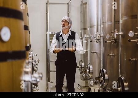 Viticulteur professionnel travaillant dans une grande usine de vinification moderne alcool alcool alcool industrie du contrôle de la qualité et de la fermentation surveillent la couleur vintage à Banque D'Images