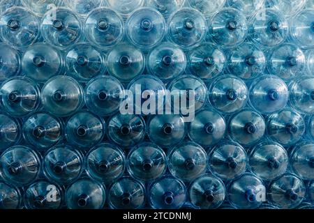 Pile de gallons d'eau. Bouteille à boire en plastique PET dans le magasin d'usine d'eau potable dans l'entrepôt de stockage d'hygiène propre. Banque D'Images