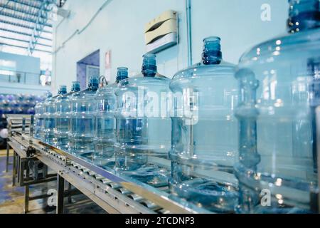 Bouteille de gallon d'eau potable en plastique PET propre dans la chaîne de production de convoyeur dans l'usine d'usine d'eau potable. Banque D'Images