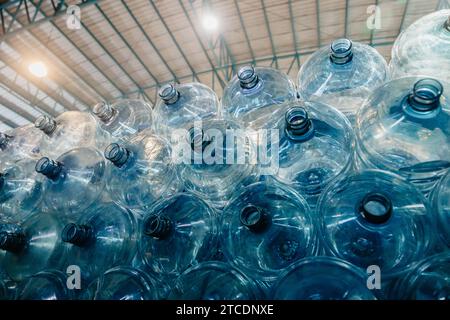 Pile de gallons d'eau. Bouteille à boire en plastique PET dans le magasin d'usine d'eau potable dans l'entrepôt de stockage d'hygiène propre. Banque D'Images