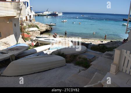 Petits bateaux couchés à l'envers sur la petite plage de la ville sicilienne de Levanzo Banque D'Images