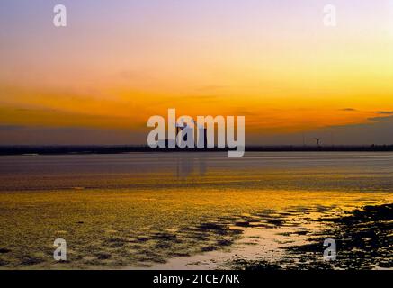 L'ancienne centrale de Richborough, Sandwich, Kent, vue au coucher du soleil depuis l'autre côté de la baie Pegwell. Elle a commencé à fonctionner comme une centrale au charbon en 1963, se transformant en centrale au mazout en 1971. À partir de 1989, il brûla l'Orimulsion, un mélange de pétrole et d'eau, très polluant, jusqu'à sa fermeture en 1996. Il a été démoli en 2012. Banque D'Images