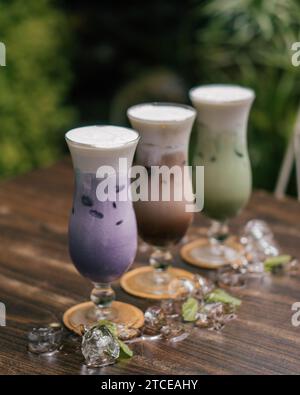 un triple verre de milk-shake frais sur une table en bois remplie de glaçons Banque D'Images