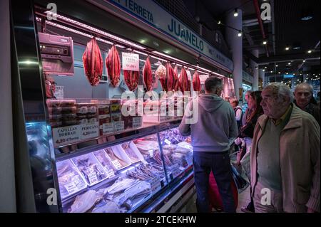 Clients à un stand avec du poisson séché dans le marché central d'Alicante. Les acheteurs profitent de l'occasion pour acheter des fruits de mer pour les repas et les dîners pour l'UP Banque D'Images