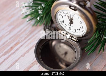 Horloge du nouvel an avant minuit. Montre de poche antique sur fond en bois Banque D'Images