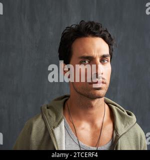 Sérieux, bouleversé et portrait d'un homme par un mur avec une expression faciale déçue, en colère ou de mauvaise humeur. Froncés, confus et jeune homme du Canada Banque D'Images