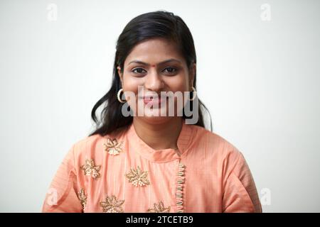 Femme indienne souriante avec bindi sur le front portant une robe de pêche Banque D'Images