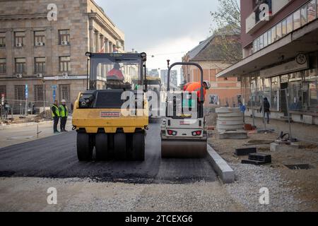 Belgrade, Serbie, le 9 décembre 2023 : rouleau pneumatique et rouleau à double tambour posant de l'asphalte le long de la rue en cours de reconstruction Banque D'Images