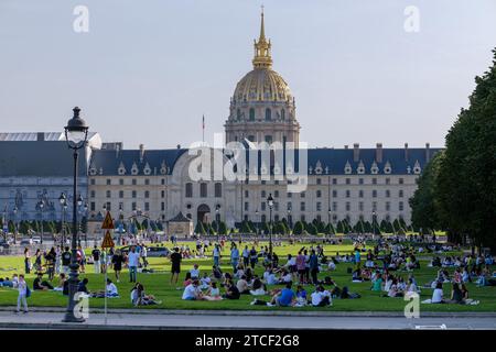 Paris, France - 8 octobre 2023 : vue d'une foule de jeunes assis en petits groupes dans un parc verdoyant devant l'Hôtel des Invalides Banque D'Images