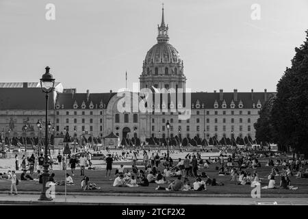 Paris, France - 8 octobre 2023 : vue d'une foule de jeunes assis en petits groupes dans un parc verdoyant devant l'Hôtel des Invalides Banque D'Images