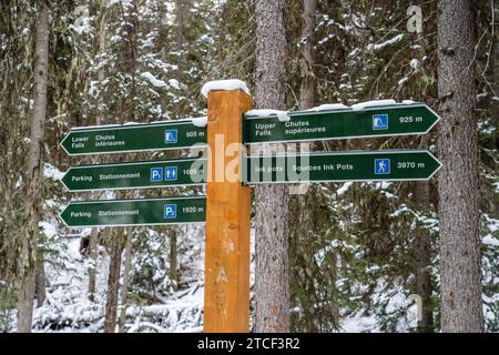 Panneau dans Johnston Canyon indiquant les directions vers les chutes d'eau et l'aire de stationnement en hiver Banque D'Images