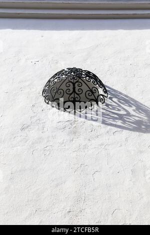 Fenêtre ronde avec treillis en fer forgé sur façade blanchie à la chaux à Ronda, Malaga, Espagne Banque D'Images