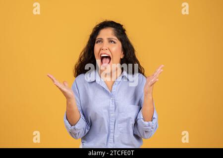 Triste désespéré latin jeune dame brune dans casual avec le cri de bouche ouverte Banque D'Images