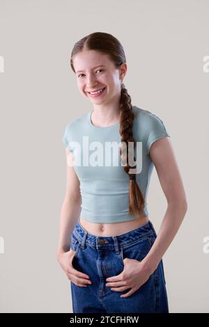 Studio Portrait d'une adolescente heureuse souriante et confiante regardant la caméra Banque D'Images