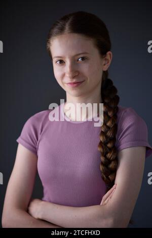 Low Key Studio Portrait d'une adolescente heureuse souriante et confiante regardant la caméra Banque D'Images