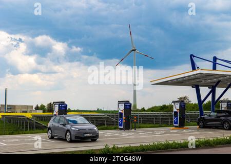 EnBW Schnellladepark Zorbau - Autohof VW-Elektroauto im Ladevorgang an der Schnellladesäule von EnBW. Im hintergrund ein Feld mit Photovoltaikanlage und eine Windkraftanlage. *** EnBW Parc de recharge rapide Zorbau Autohof VW recharge de voiture électrique à la station de recharge rapide EnBW en arrière-plan un champ avec un système photovoltaïque et une éolienne 20230512-6V2A7896 Banque D'Images