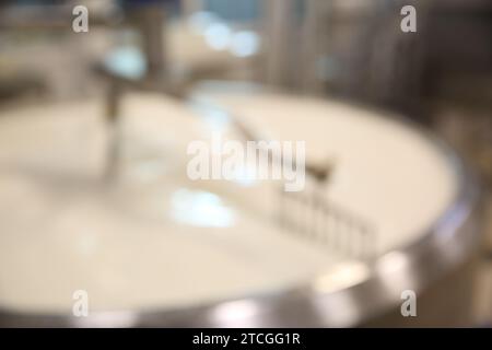 Vue floue du réservoir de préparation de caillé avec du lait à l'usine de fromage Banque D'Images