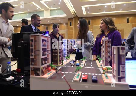 Gouvernorat de Hawalli, Koweït. 12 décembre 2023. Les gens regardent un modèle de projet de feux de circulation contrôlés par l'intelligence artificielle à l'exposition des projets de graduation des étudiants en génie dans le gouvernorat de Hawalli, Koweït, le 12 décembre 2023. Crédit : Yin Ke/Xinhua/Alamy Live News Banque D'Images