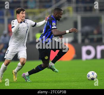 Milan, Italie. 12 décembre 2023. Marcus Thuram (droite) du FC Inter défie Aihen Munoz de la Real Sociedad lors du match du Groupe D de l'UEFA Champions League entre le FC Inter et la Real Sociedad à Milan, Italie, le 12 décembre 2023. Crédit : Augusto Casasoli/Xinhua/Alamy Live News Banque D'Images