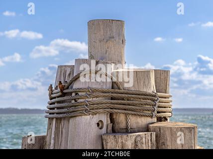 image détaillée des pilotis en bois enveloppés dans un câble en acier Banque D'Images